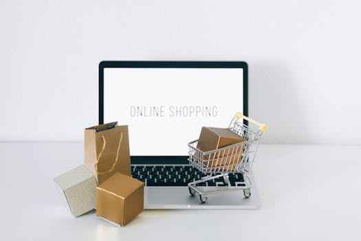 Laptop displaying online shopping with boxes and cart, representing ecommerce.